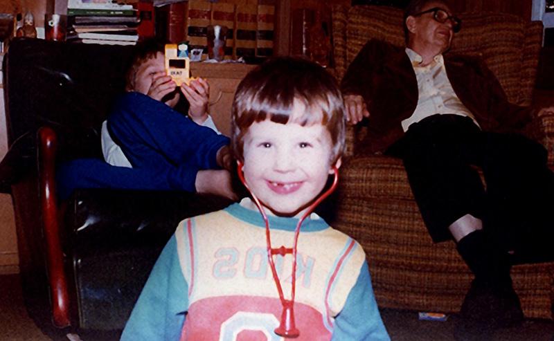 Greg Friberg as a young child playing with a stethoscope.